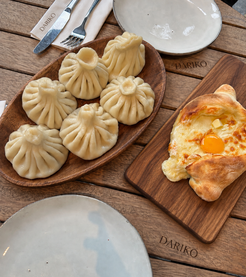 Hand-folded khinkali beside freshly baked Adjarian khachapuri at DARIKO
